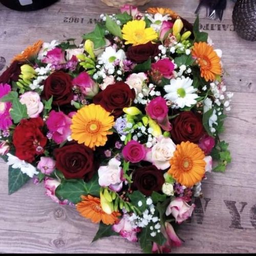 Blumengesteck in Herzform mit bunten Blumen